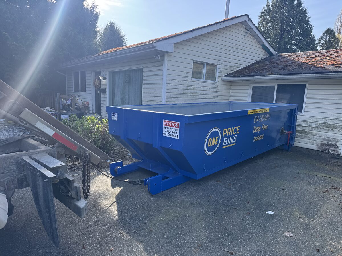 One Price Bins roll-off bin delivered to a residential driveway
