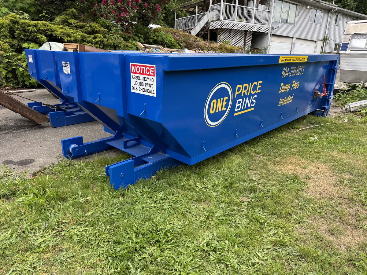 One Price Bins roll-off bin on grass at a residential property
